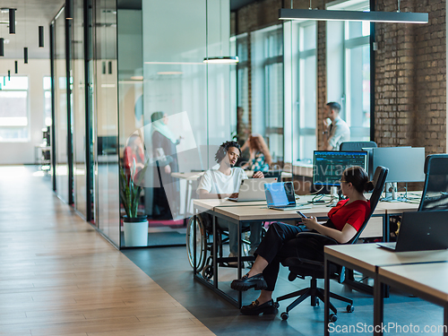 Image of A diverse group of young business individuals congregates in a modern startup coworking center, embodying collaborative innovation and a dynamic atmosphere