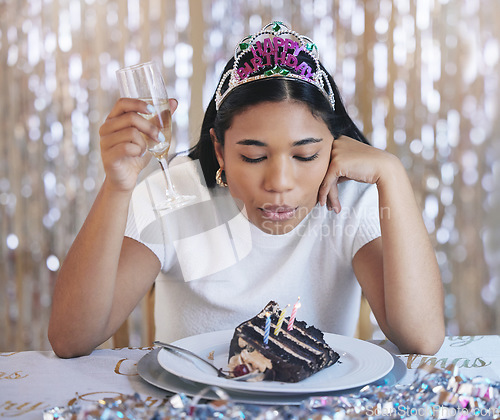 Image of Sad woman birthday cake, celebrate home alone with champagne and sad at lonely pandemic party celebration. Young latino girl fail to blow candle on table, wish thinking and shiny crown decoration