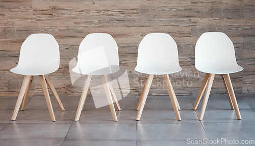 Image of Hiring staff recruitment drive, interview waiting room and four white office chairs in empty wood wall background. Business opportunity in corporate space and available position to join the team