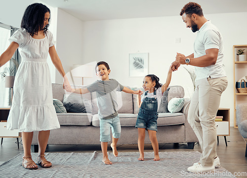 Image of Happy family, dancing and having fun while sharing love, energy and bond while holding hands in the living room at home. Man, woman and sibling kids playing and laughing enjoying active time together