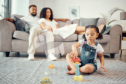 Image of Child, development and toy blocks while learning motor skill and colors while building a tower in lounge at home with parents or adult supervision. Girl kid playing and fun with educational activity