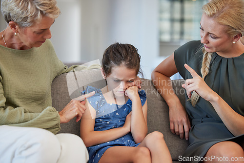 Image of Family, discipline and warning by mother and grandmother hand sign to girl for bad behaviour on a sofa at home. Autism, adhd and communication by parent and daughter in conflict with attitude problem