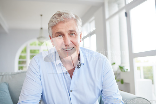 Image of Happy senior, smile and retired man sitting alone on the sofa in the living room enjoying his retirement and free time at home. Portrait of an elderly male looking at a webcam for a video call