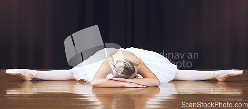 Image of Ballet, stage and dance with woman stretching in split training and getting ready for theatre, performance or show. Creative, motivation and art with ballerina dancer in studio dancing for recital