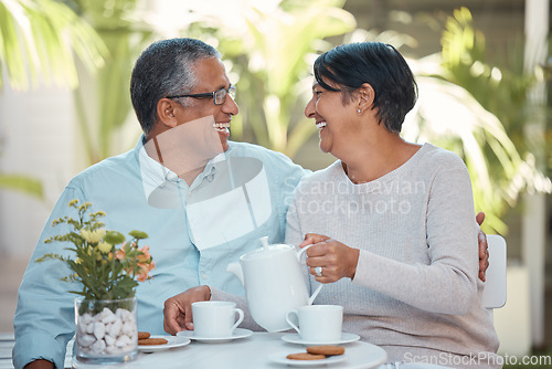 Image of Mature couple laughing, drinking tea and bonding in backyard together, relax and cheerful outdoors. Senior man and woman enjoying retirement and their relationship,sharing a joke and tea time snack