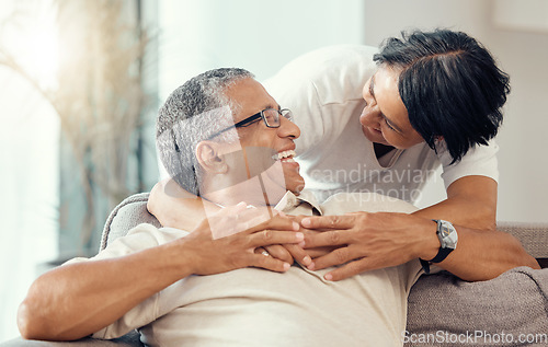 Image of Love, senior couple and hug while laughing, bonding and sharing a romantic moment during retirement on the sofa at home. Joy, commitment and healthy relationship of an elderly man and woman together