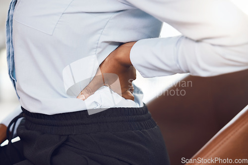 Image of Business woman with back pain from stress in the office while sitting at a corporate company. Closeup of the hand of a black professional employee holding a medical muscle injury, backache or sprain.