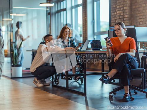 Image of A diverse group of young business individuals congregates in a modern startup coworking center, embodying collaborative innovation and a dynamic atmosphere