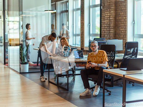 Image of A diverse group of young business individuals congregates in a modern startup coworking center, embodying collaborative innovation and a dynamic atmosphere