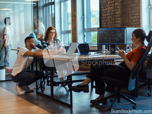 Image of A diverse group of young business individuals congregates in a modern startup coworking center, embodying collaborative innovation and a dynamic atmosphere