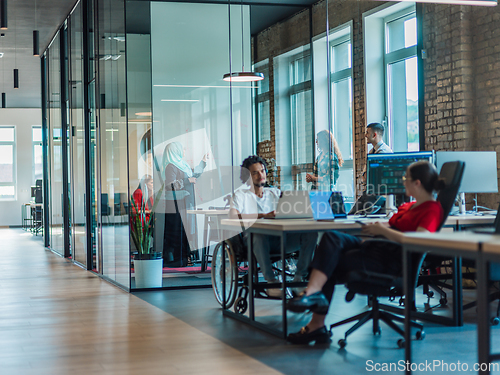 Image of A diverse group of young business individuals congregates in a modern startup coworking center, embodying collaborative innovation and a dynamic atmosphere