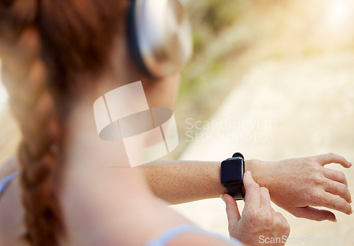 Image of Fitness woman, smartwatch and sports woman outside tracking progress for exercise, cardio training and outdoor workout for health. Closeup active female athlete using mobile music app to track steps