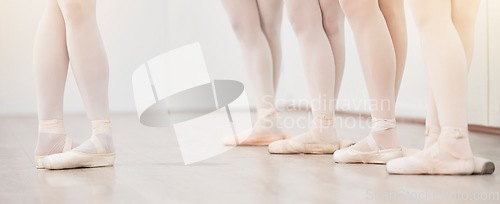 Image of Ballet, leader and dancer group feet in dance studio training in artist academy with white wall and floor. Women team, class or students dancing on pointe shoes for school performance with lens flare