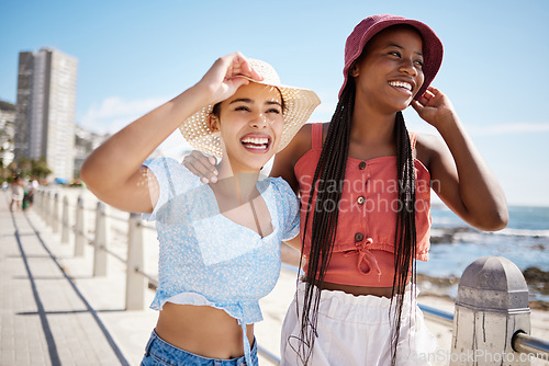 Image of Summer, fashion and gen z girl friends in the city near the beach or ocean for holiday, vacation or youth wellness. Vitamin d, happiness and love with young women wearing hat outdoor in the sunshine