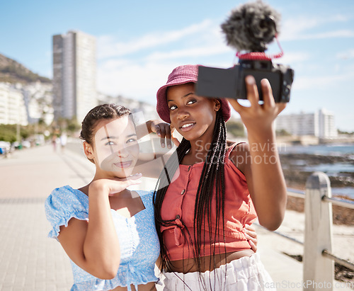 Image of Live streaming holiday, beach travel and friends working on video podcast on international vacation in Miami, selfie with camera and summer content. African influencer women talking photo by the sea