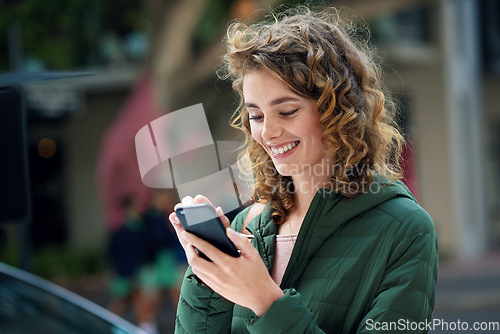 Image of Happy woman, smile and typing on phone during travel in city using social media, internet and 5g network connection outside. Young female flirting on a mobile app for communication on urban street