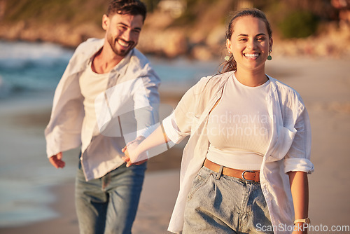 Image of Happy couple, beach and travel while holding hands, laughing and having fun on Portugal summer vacation or holiday traveling to seaside. Smile of man and woman on honeymoon sharing love and adventure