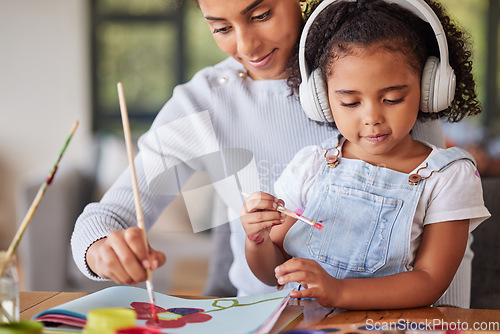 Image of Mother, girl and bonding in painting activity with music headphones, radio or audio for autism help. Brazilian woman, art parent and creative child listening to relax autism podcast in house or home