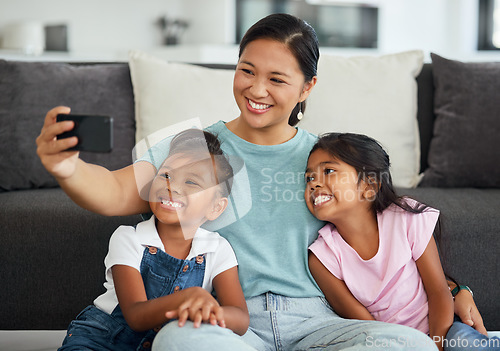 Image of Selfie, family and children with a girl, daughter and foster mother taking a photograph in a living room of the home. Kids, love and affection with a woman, sister and sibling together in a house
