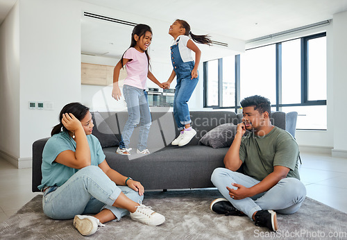 Image of Family, energy and kids jumping on home sofa with tired parents struggling with naughty, hyperactive and playing children. Woman and man with ADHD, noisy and laughing girls, friends or fun twins