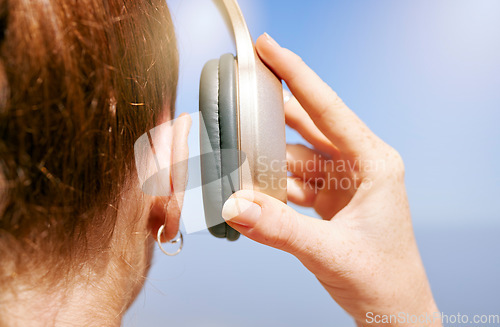 Image of Hands of woman with headphones listening to music for peace of mind, freedom and relax outdoor back view. Podcast, radio and calm girl streaming rock, disco or jazz audio song for wellness mindset