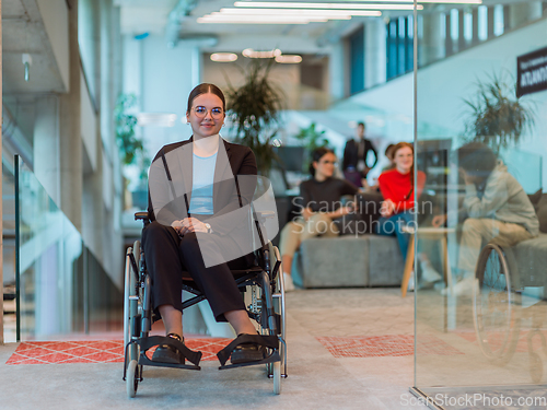 Image of In a modern office, a young businesswoman in a wheelchair is surrounded by her supportive colleagues, embodying the spirit of inclusivity and diversity in the workplace