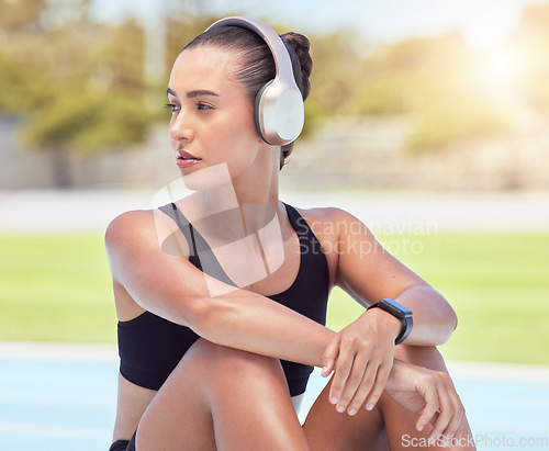 Image of Music, fitness and relax with a sports woman taking a break from her workout, exercise and training for health and cardio. Health and wellness with a female athlete listening to audio on headphones