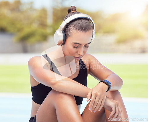 Image of Sport runner woman listening to music on break from training, exercise and fitness workout. Tired athlete rest to recover from pain, prevent muscle injury and physical exhaustion or medical emergency