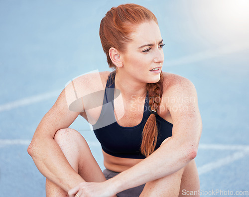 Image of Sports track, fitness and runner on break while training for marathon or olympic competition. Running, exercise and confused athlete sitting on floor while thinking and resting during cardio workout.