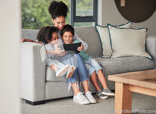 Image of A mother with children on couch with tablet to watch educational shows and streaming music. Foster or adoption parent with kids in living room watch cartoons, playing online games and homeschooling.