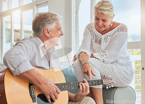 Image of Old couple, guitar and love in home, sofa or couch playing a romantic, lovely or affection musical song for wife. Romance, retired senior man and woman play acoustic string instrument in living room.