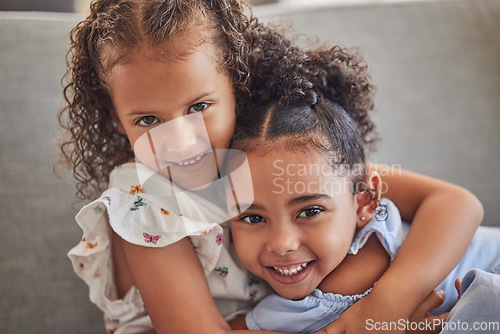 Image of Happy, smile and portrait of sisters hugging while sitting on a sofa in the living room at the family home. Happiness, love and girl siblings from puerto rico bonding while relaxing on couch together