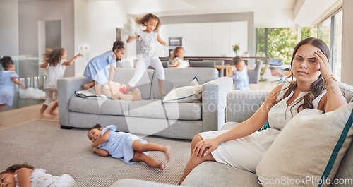 Image of Stress, headache and children running, with mother in living room together with family, mental health and fatigue. Sad, tired and anxiety with mom on sofa while kids play in lounge for crazy or youth