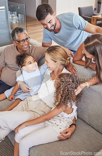 Image of Happy interracial family bonding with their children and grandparents at home. Adults and their kids smile while sitting on the sofa, laugh and hug in a living room during vacation in a holiday house