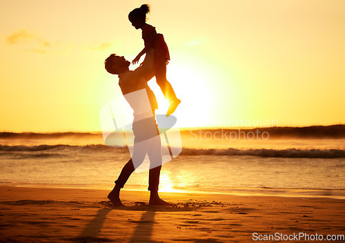 Image of Father, girl and beach at sunset happy, silhouette of man and child together play on sand. Parent, ocean and sun, rising or setting over the horizon in nature, on vacation or family travel by the sea