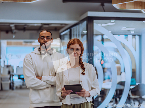 Image of In a modern office African American young businessman and his businesswoman colleague, with her striking orange hair, engage in collaborative problem-solving sessions