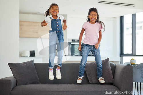 Image of Excited girl kids jumping on living room sofa furniture at home for fun, energy and play games. Portrait crazy, happy and wild young children adhd, action and funny laughing bounce on lounge couch