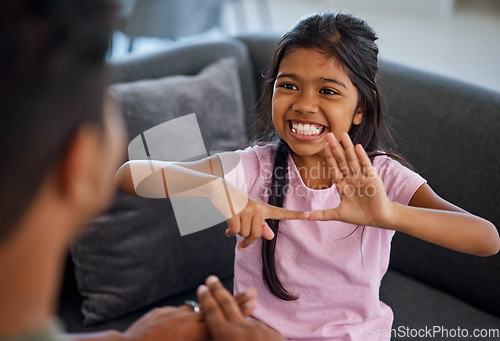 Image of Child, sign language and learning to communicate with deaf girl or parent while making fingers and showing visual symbols at home. Happy kid with hearing disability or loss sitting with a tutor