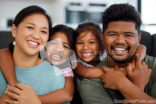 Image of Family, smile and love of children for their mom and dad while sitting together in the lounge at home sharing a special bond. Portrait of happy Filipino man, woman and girl kids hugging their parents