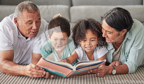 Image of Family, book and children reading development growth at home with grandparents on the floor. Kids, elderly and happy people looking at books, story and pictures encourage fun learning and studying