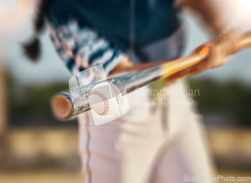 Image of Baseball player, bat and ball while swinging during sports game, match or training outside. Closeup of a fit female, professional athlete and hands of a competitive woman playing in a competition