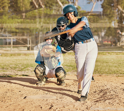 Image of Baseball player, female athlete and swinging bat with sports technique or skill while playing a competitive game or match on a pitch or field. Fit female with a catcher doing exercise and recreation