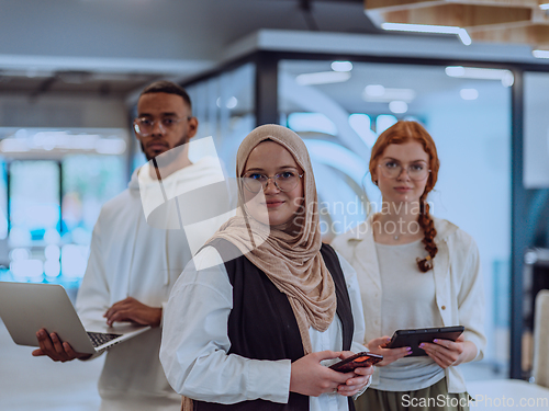 Image of A diverse group of young business individuals is captured in a professional portrait at a modern office, reflecting their teamwork, ambition, and creativity in a vibrant and dynamic corporate setting