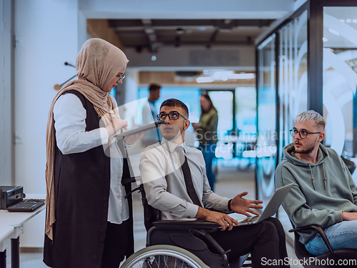 Image of Young group of business people brainstorming together in a startup space, discussing business projects, investments, and solving challenges.