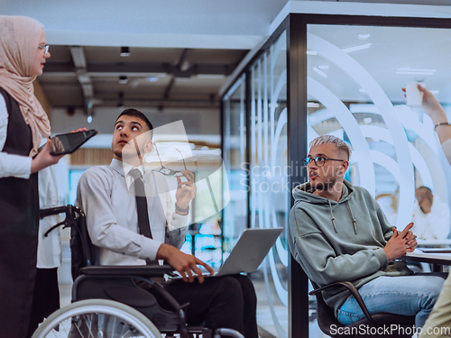 Image of Young group of business people brainstorming together in a startup space, discussing business projects, investments, and solving challenges.