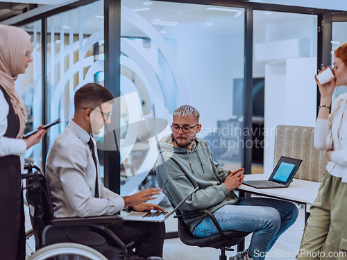 Image of Young group of business people brainstorming together in a startup space, discussing business projects, investments, and solving challenges.