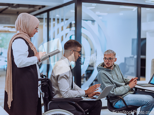 Image of Young group of business people brainstorming together in a startup space, discussing business projects, investments, and solving challenges.