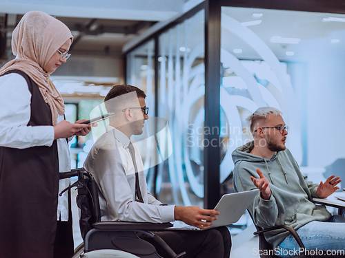 Image of Young group of business people brainstorming together in a startup space, discussing business projects, investments, and solving challenges.