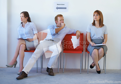 Image of Recruitment, man or women in waiting room for job interview, hiring and cv in company building. Business people, sitting or patience with resume, documents or paperwork for onboarding or bored yawn