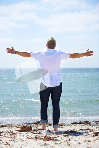 Image of Beach, back and senior man with open arms freedom in nature for travel, adventure or celebration. Ocean rear view an elderly male person with retirement vacation at the sea with gratitude in Bali